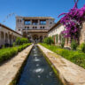 Water jets in the gardens of Generalife Alhambra with the building, Granada