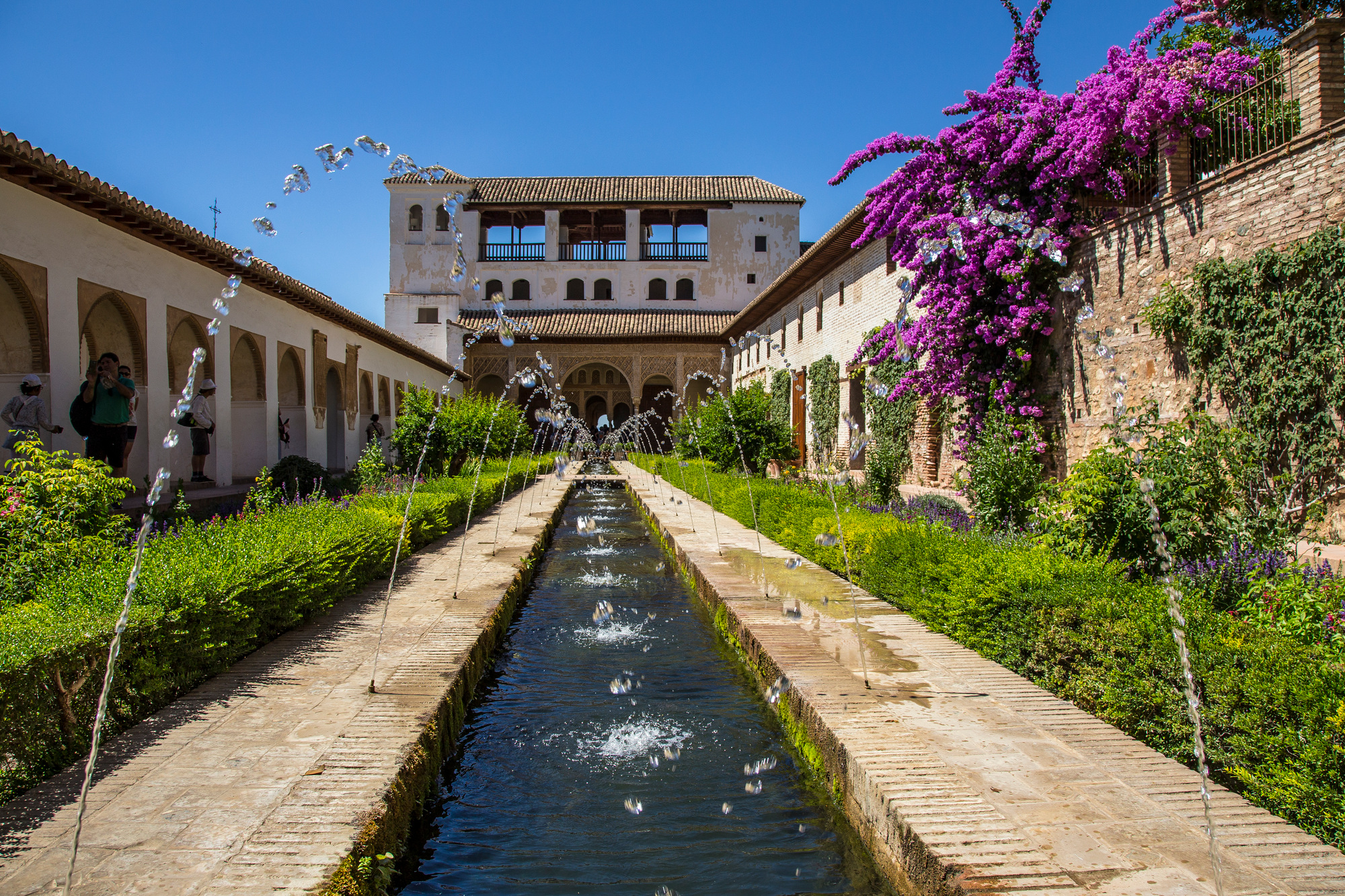 Water jets in the gardens of Generalife Alhambra with the building, Granada