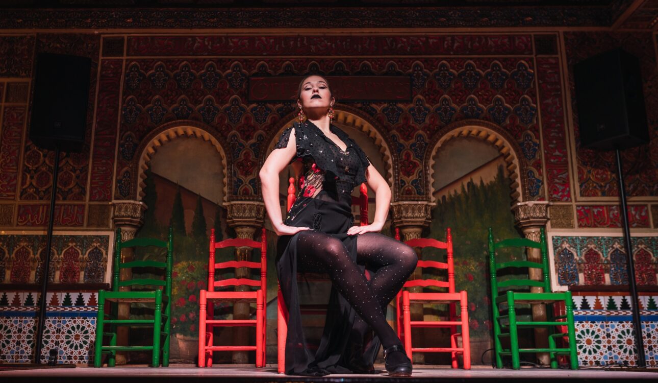 Woman in dress dancing flamenco on scene