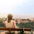 female traveler contemplates the views of the Alhambra palace in the city of Granada, Spain