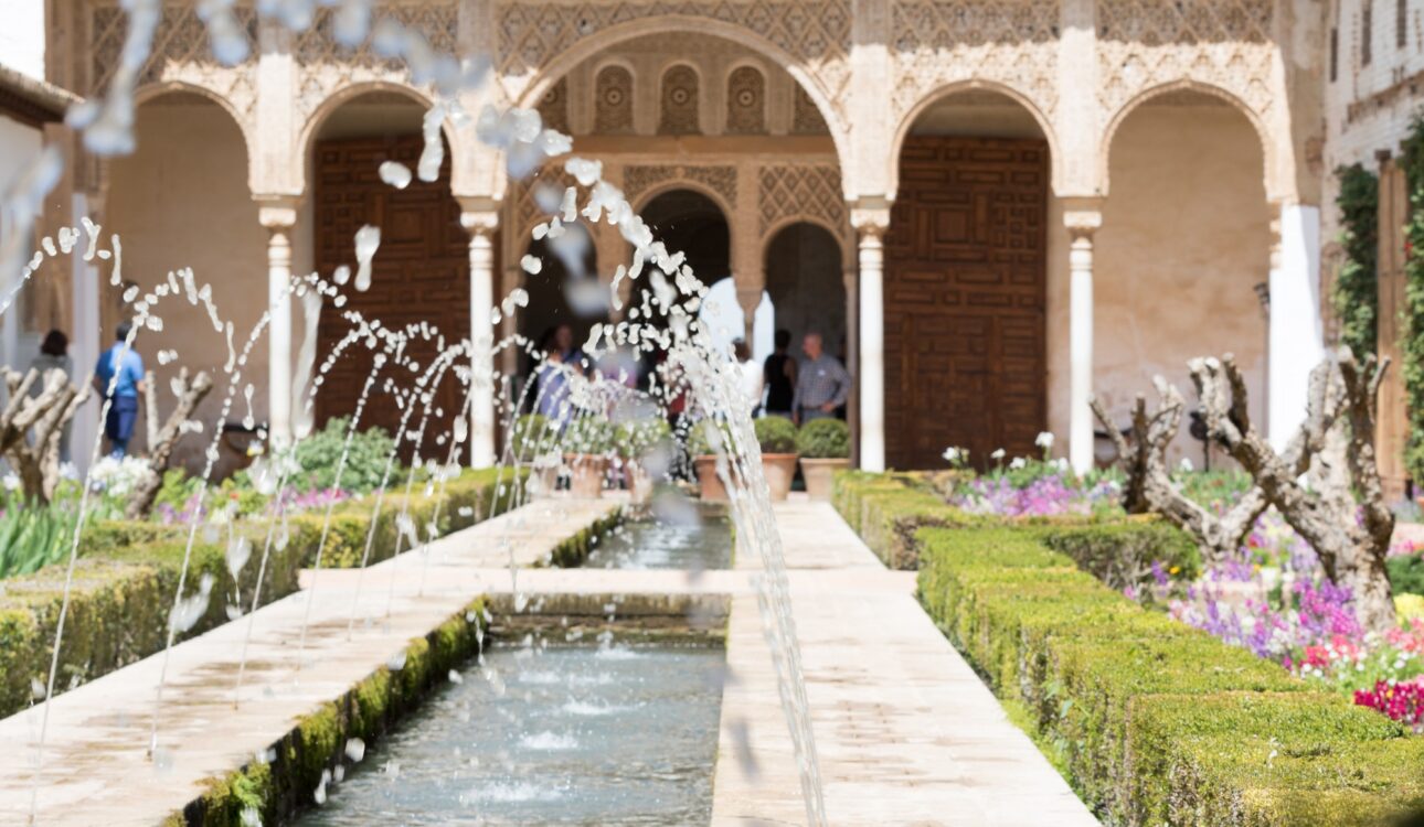 Granada, Spain - May 10, 2018: crowd of tourists near the fountain inside the city of the Alhambra